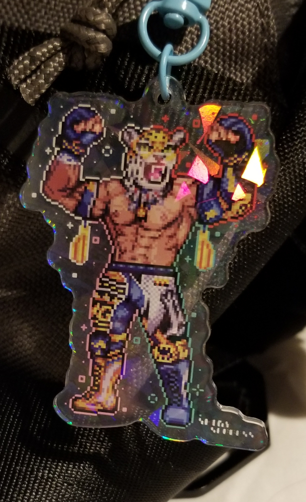 A shiny, reflective acrylic charm of King (from Tekken) flexing and showing of his muscles.
