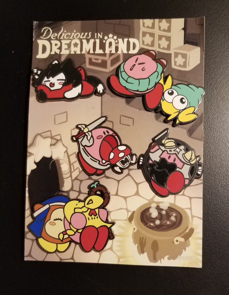 A pin set designed by Sylph, named "Delicious in Dreamland." A crossover between Nintendo's Kirby and an anime called Delicious in Dungeon.