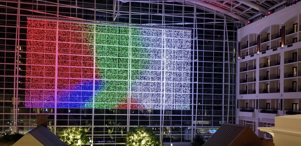A shot of the Gaylord convention center with a lightshow being projected onto its large window.